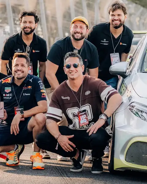 Capa do reel: time da Beehive e convidados ao lado de um carro na pista de Interlagos